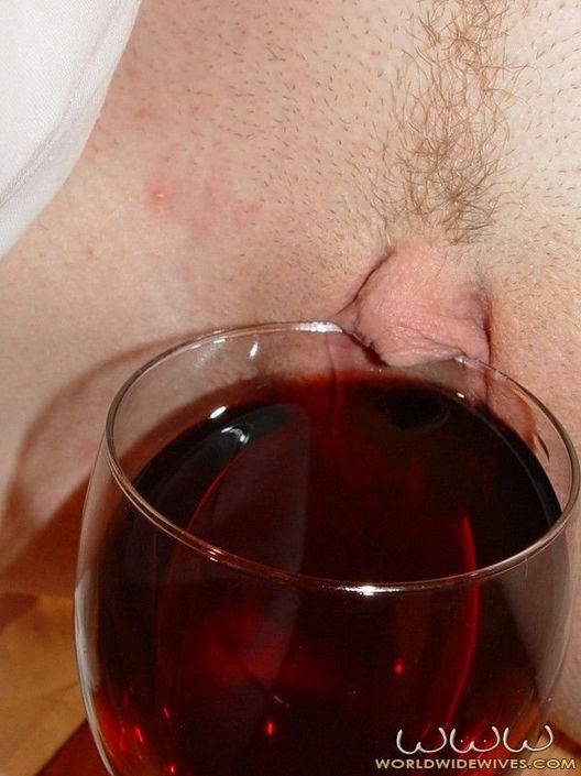 Пьяная брюнетка сексуально позирует голой пиздой с бокалом вина призывая устроить еблю