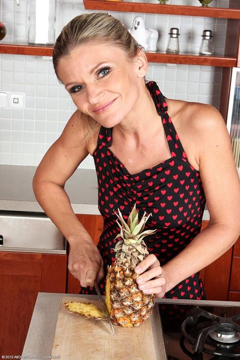Симпатичная зрелая женщина с ананасом на кухне обнажается и мастурбирует пилотку до оргазма